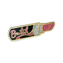 Load image into Gallery viewer, A gold enamel pin of a open black tube of pink glittery lipstick with "Butch" in pink glitter is written on the side of the tube.