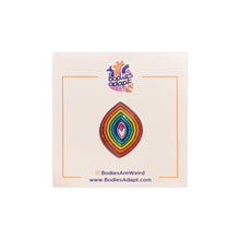 Load image into Gallery viewer, Enamel pin of a pointed oval with sparkly rainbow sections in a vagina shape on a white card with an anatomically correct heart with the words &quot;bodies adapt&quot; inside it. 