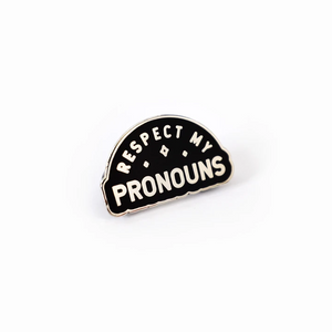 Semi-circle shaped enamel pin that reads "respect my pronouns" in white on a black background with white sparkles. 