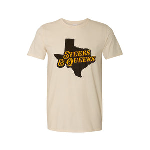 A picture of a tan t-shirt with a brown silhouette of Texas with "Steers & Queers" in a western style yellow font over top.