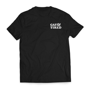 A picture of a black t-shirt with the phrase "Gay & Tired" on the left breast of the shirt.