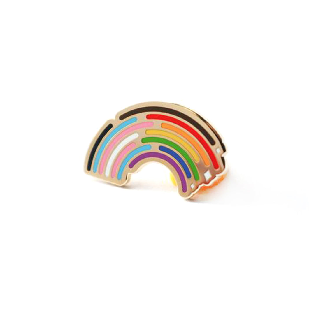 Gold enamel pin of a rainbow that starts with the trans flag colors and fades into the inclusivity pride rainbow that includes the black and brown stripes, the rainbow has a staggered ending to each stripe with white sparkles at the end.